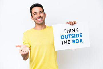 Young handsome man over isolated white background holding a placard with text Think Outside The Box making a deal