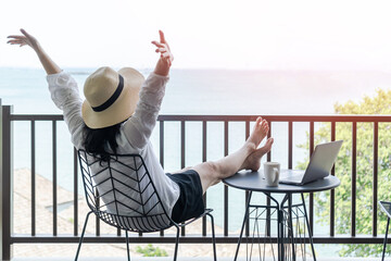Worl-life balance, relaxation healthy quality living lifestyle in summer holiday vacation of freelancer woman take it easy celebrating resting in resort hotel balcony with sea view with peace of mind