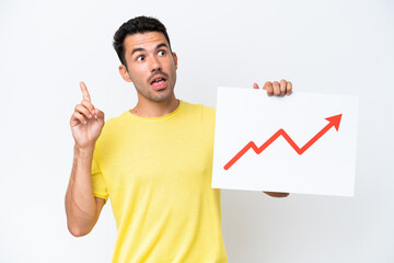 Young handsome man over isolated white background holding a sign with a growing statistics arrow symbol and thinking