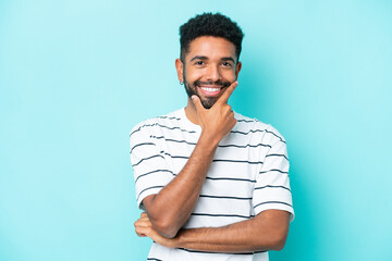 Young Brazilian man isolated on blue background happy and smiling