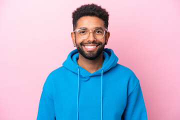 Young Brazilian man isolated on pink background With glasses with happy expression
