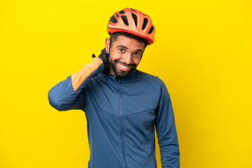 Young cyclist Brazilian man isolated on yellow background laughing