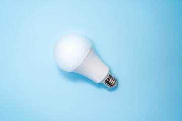 Energy saving light bulb on blue background. Savings