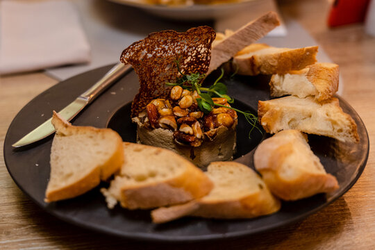 Delicious pate with nuts, greens and toasted bread on a plate