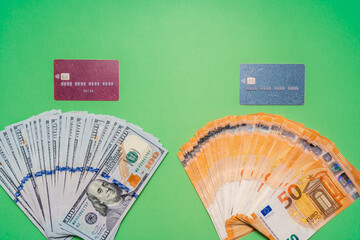 Cash of dollar and euro with credit cards on green background