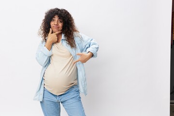 Pregnant woman brooding motherhood on a white isolated background in a t-shirt with a blue shirt