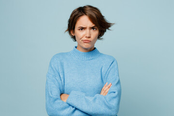 Young sad offended unhappy caucasian woman wearing knitted sweater look camera hold hands crossed...