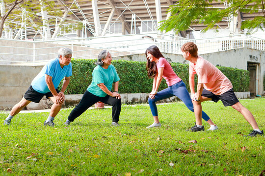 Asian family exercising outdoors in the morning They smile happily. Sport concept, fitness family, health care. - Powered by Adobe