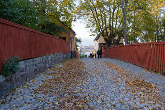 Small pavement street with red fences in Stockholm, Sweden
