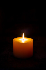 Fototapeta na wymiar A light of the white candle in a dark room.