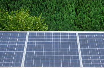 Blick auf eine Photovoltaikanlage zusammengesetzt aus mehreren Solarpanels mit grüner Natur aus...