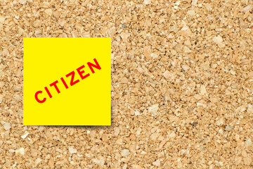Yellow note paper with word citizen on cork board background with copy space