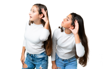 Friends girls holding gift and a birthday cake over isolated chroma key background listening to something by putting hand on the ear