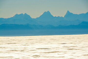 Panoramic view of Wetterhorn, Schreckhorn and Finsteraarhorn in the Swiss Alps, above a sea of clouds and fog, view from Röti peak in Solothurn Jura, Switzerland