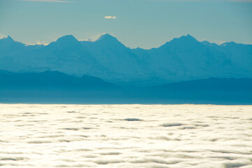 Panoramic view of Eiger, Mönch and Jungfrau in the Swiss Alps, above a sea of clouds and fog, view from Röti peak in Solothurn Jura, Switzerland