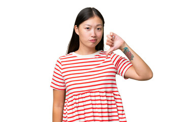 Young Asian woman over isolated background holding copyspace imaginary on the palm to insert an ad