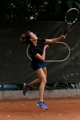shot in motion of sports female tennis player with tennis racket in her hand raised up