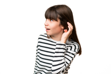 Little caucasian girl over isolated background listening to something by putting hand on the ear