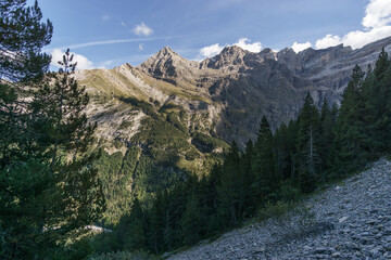 Cirque de Gavarnie with massive high rock wall formation and forest in foreground in Pyrenees...