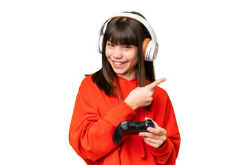 Little caucasian girl playing with a video game controller over isolated background pointing to the side to present a product © luismolinero