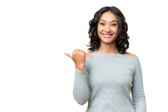 Young Argentinian woman over isolated background pointing to the side to present a product