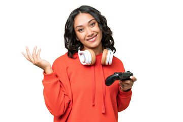 Young Argentinian woman playing with a video game controller over isolated background extending hands to the side for inviting to come © luismolinero