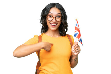 Young Argentinian woman holding an United Kingdom flag over isolated background with surprise facial expression