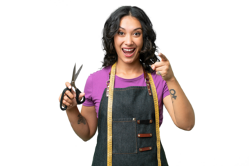 Young seamstress argentinian woman over isolated background surprised and pointing front