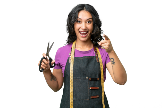 Young seamstress argentinian woman over isolated background surprised and pointing front