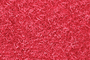 Abstract textured background in viva magenta color. Top view of walnut shavings in pink shade. Beautiful glamorous texture like copy space.