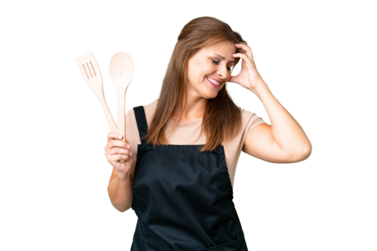 Middle age caucasian woman holding a rolling pin over isolated background smiling a lot