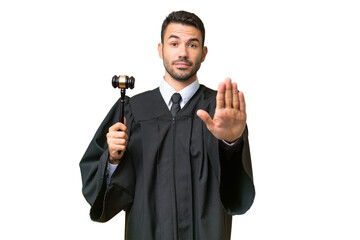 Judge caucasian man over isolated background making stop gesture