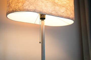 A modern-luxury design lighting lamp which is glowing in orange warm light shade. Interior decoration object photo, close-up and selective focus.