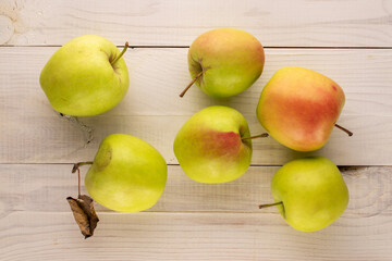 Several sweet green apples on wooden table, macro, top view.