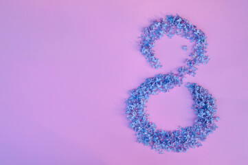 Figure 8 made of flowers on pink background. Happy International Womens Day celebrate on March, congratulatory card