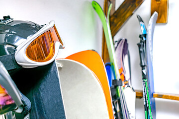 Helmet, ski mask, ski on customized wall mount at warehouse. Extreme winter sport equipment