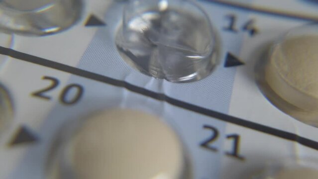 Concept of contraception and birth control. Maco shot of the spinning table of the colorful pills with numbers. High quality 4k footage
