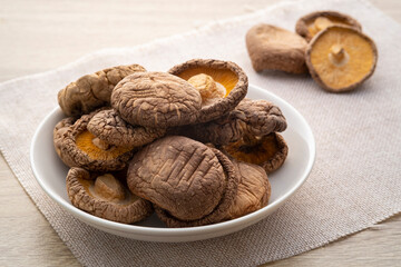 Dried shiitake mushrooms in white plate on table