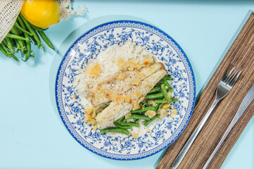 Lebanese-style fried fish on a serving dish with onion flavoured rice and roasted almond slivers.