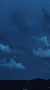 Night scene landscape of big clouds in the dark sky 4k timelapse Vertical video