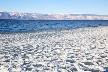 The beginning of the freezing of Lake Baikal on a sunny December day. Winter landscape. Snow and...