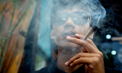 Young man smoking cigarettes with medical marijuana
