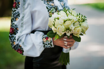 A bouquet of flowers in the hands of the bride. A bouquet of white flowers in the hands of a woman. Wedding