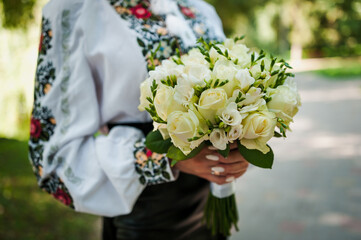 A bouquet of flowers in the hands of the bride. A bouquet of white flowers in the hands of a woman. Wedding
