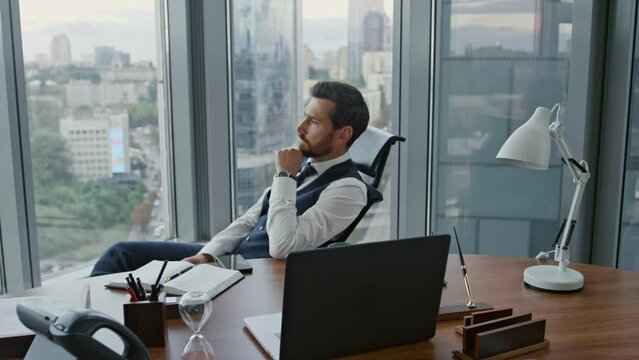 Businessman reading phone message sitting office. Manager worried about business