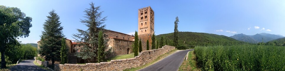 Fototapeta na wymiar The romanesque monastery of St Michel de Cuxa with its bell tower and Pic du Canigou mountain near Prades, Pyrénées-Orientales in France