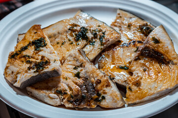 Pieces of swordfish cooked and garnished with garlic and parsley sauce 