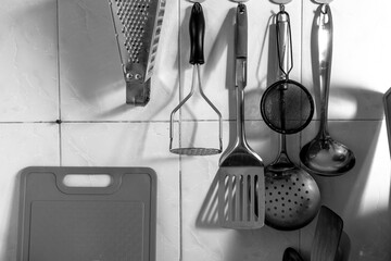 Metal appliances for cooking. Kitchen accessories hang on the wall. The wall with kitchen...