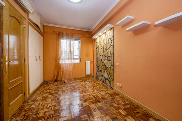 Empty room with peach walls, fitted wardrobes, oak joinery and checkerboard style slat parquet floors