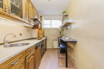 Kitchen with rustic-style oak furniture and a small table with high stools